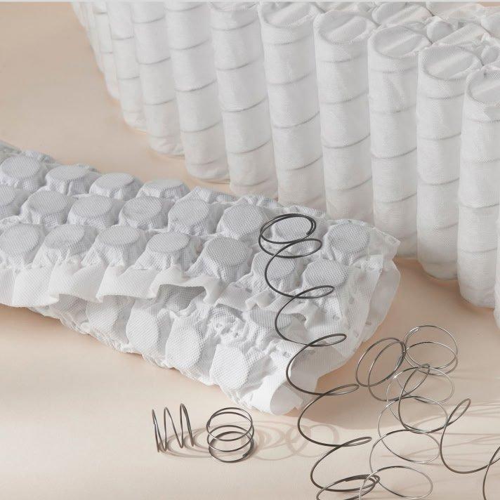 a bunch of white sheets and some metal springs on a table